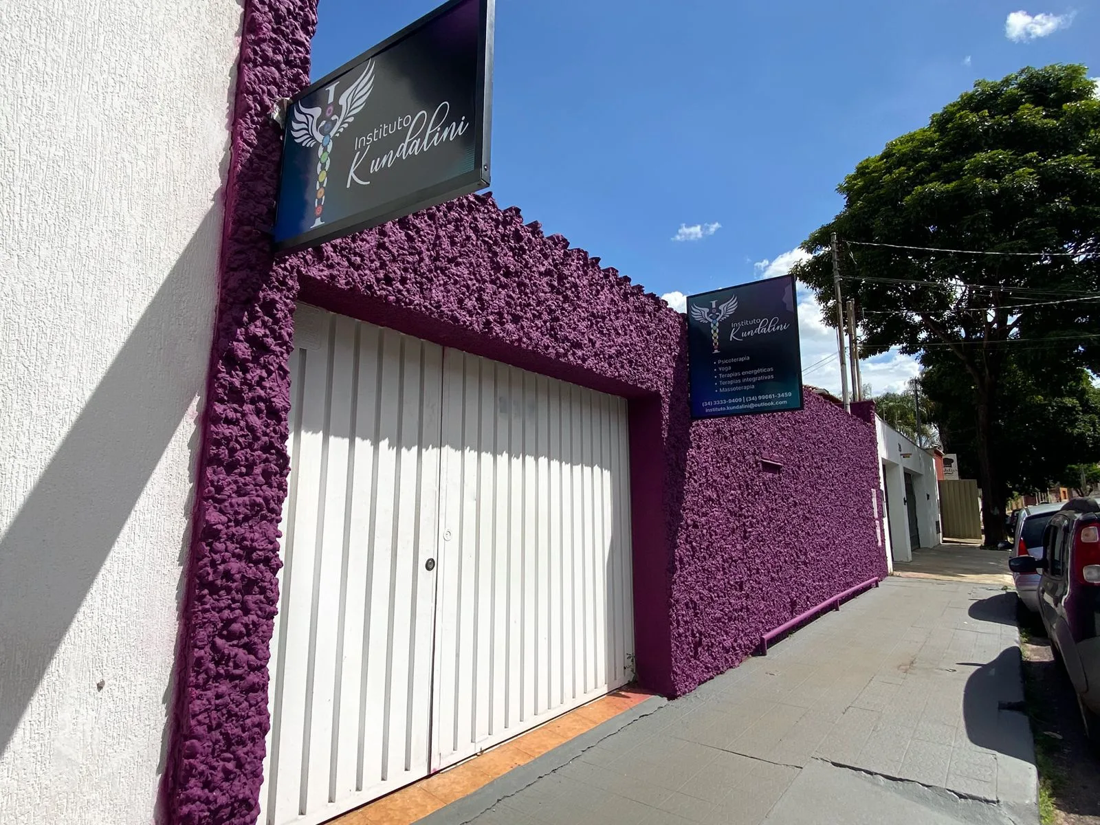 Fachada do Instituto Kundalini: muro roxo texturizado, portão branco e placa com o nome da clínica